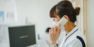 電話する白衣の女性